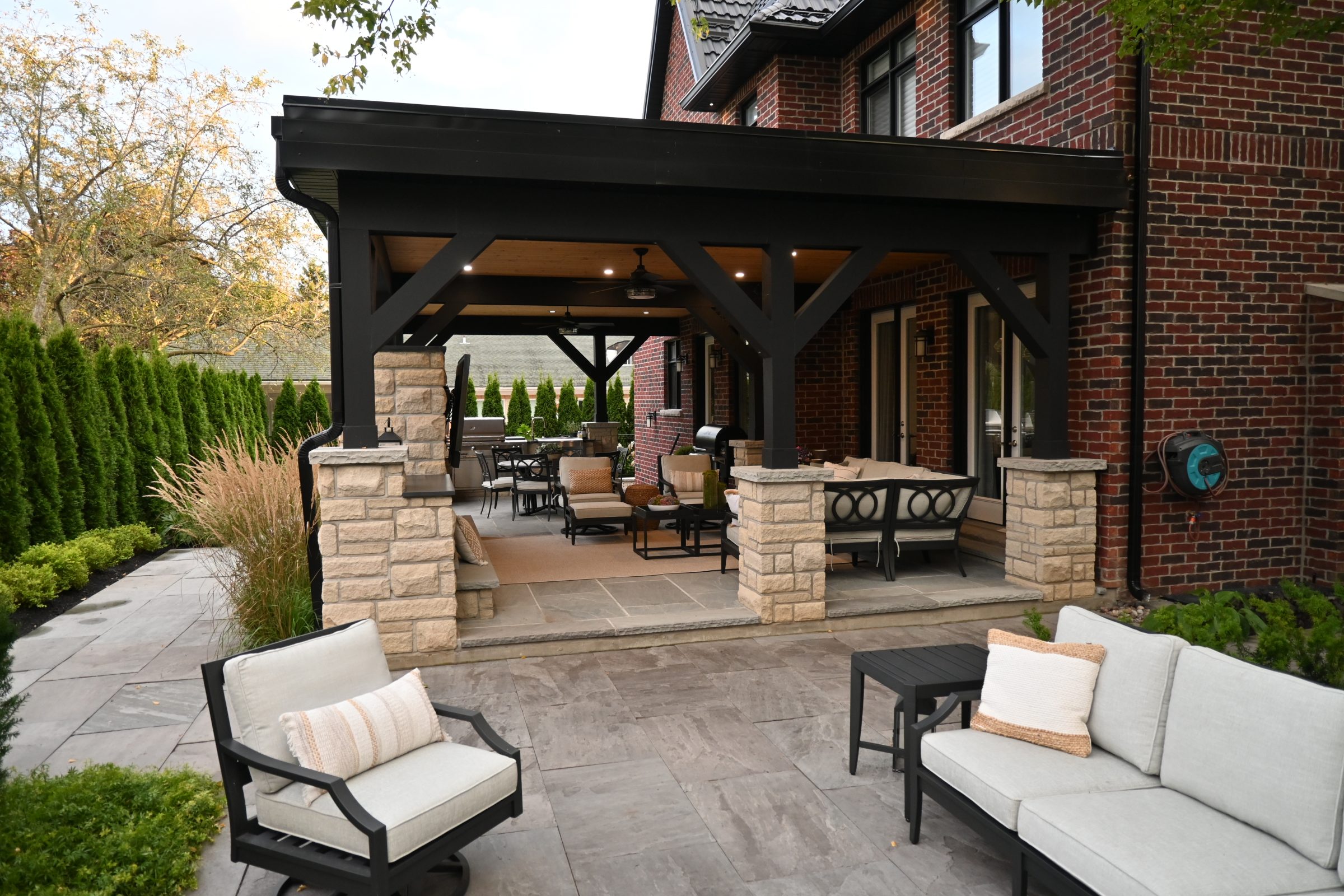 Backyard patio with seating and brick house view.
