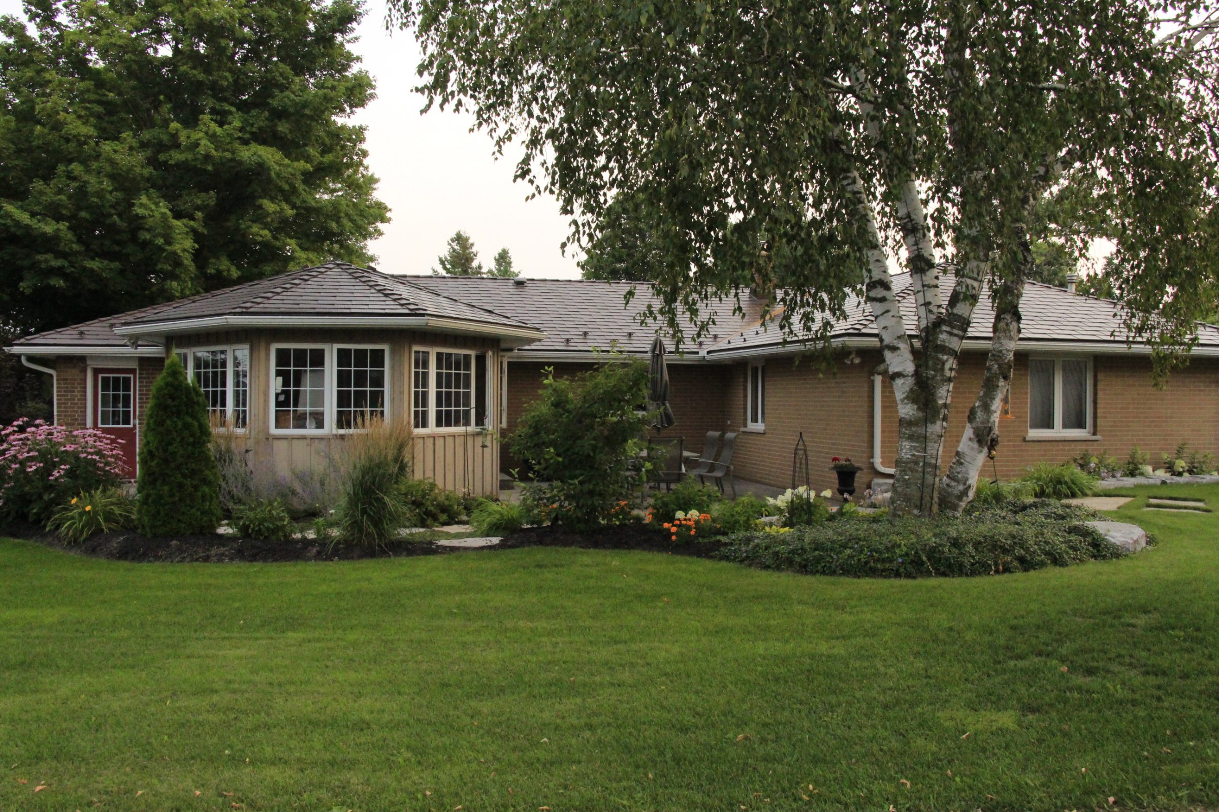 Single-story house with garden and trees