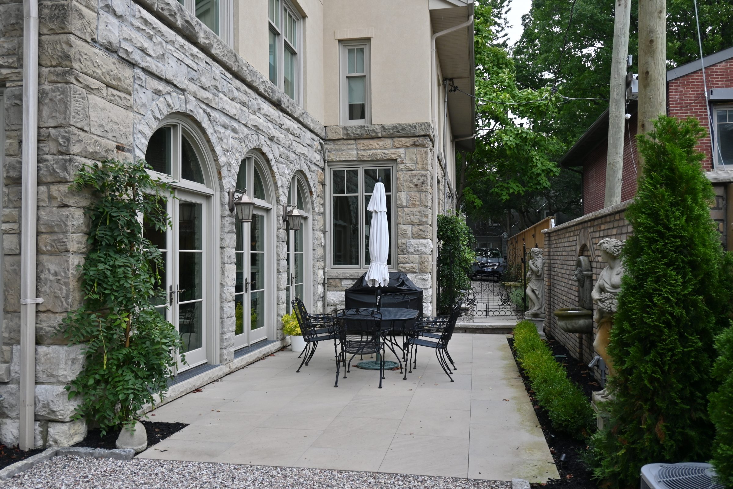 Stone patio with table, chairs, and statues