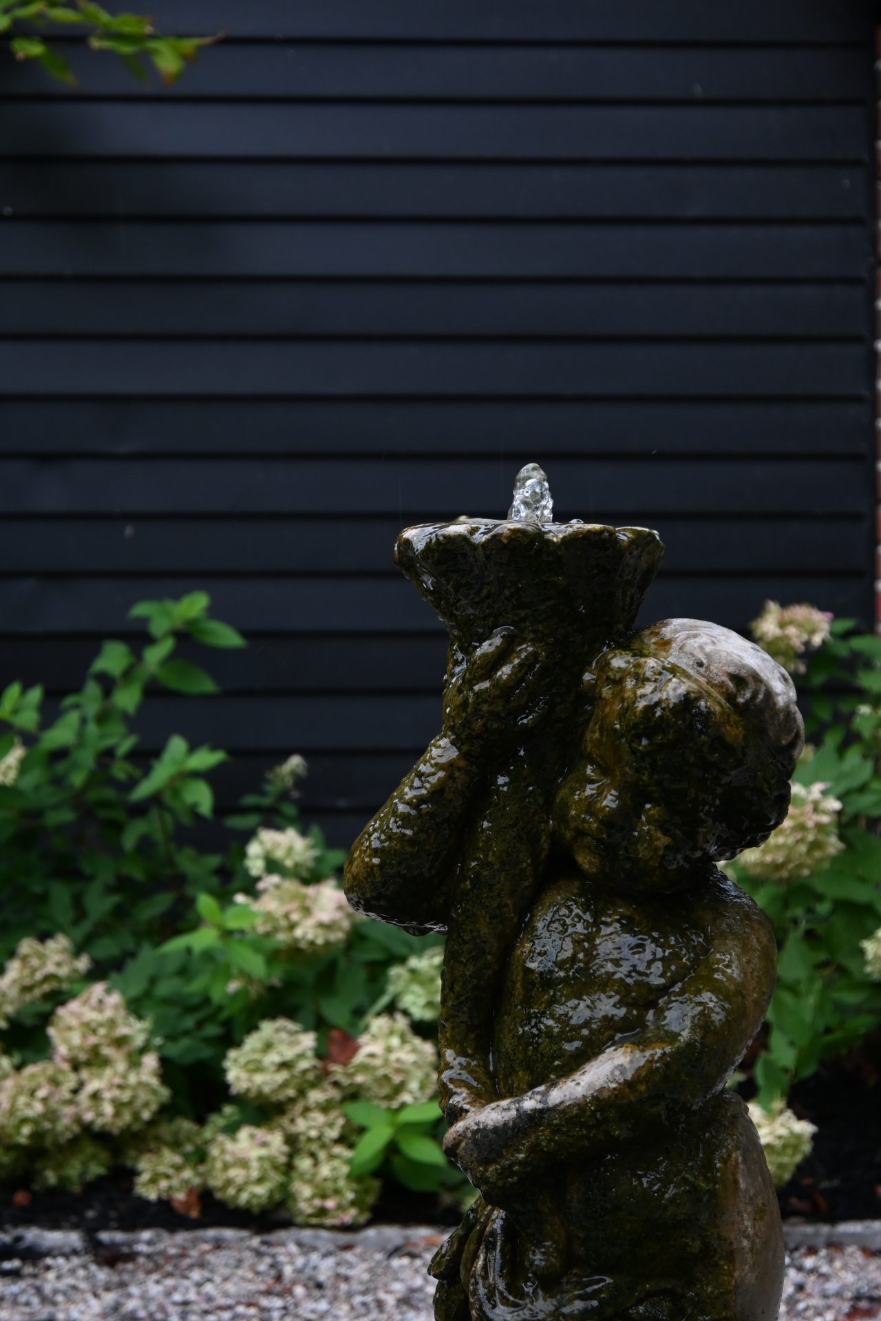 Stone cherub fountain with black wall background