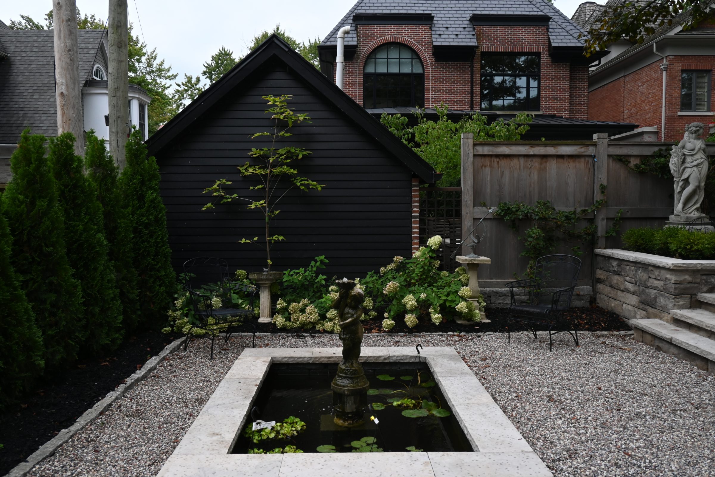 Garden with pond, statue, and greenery