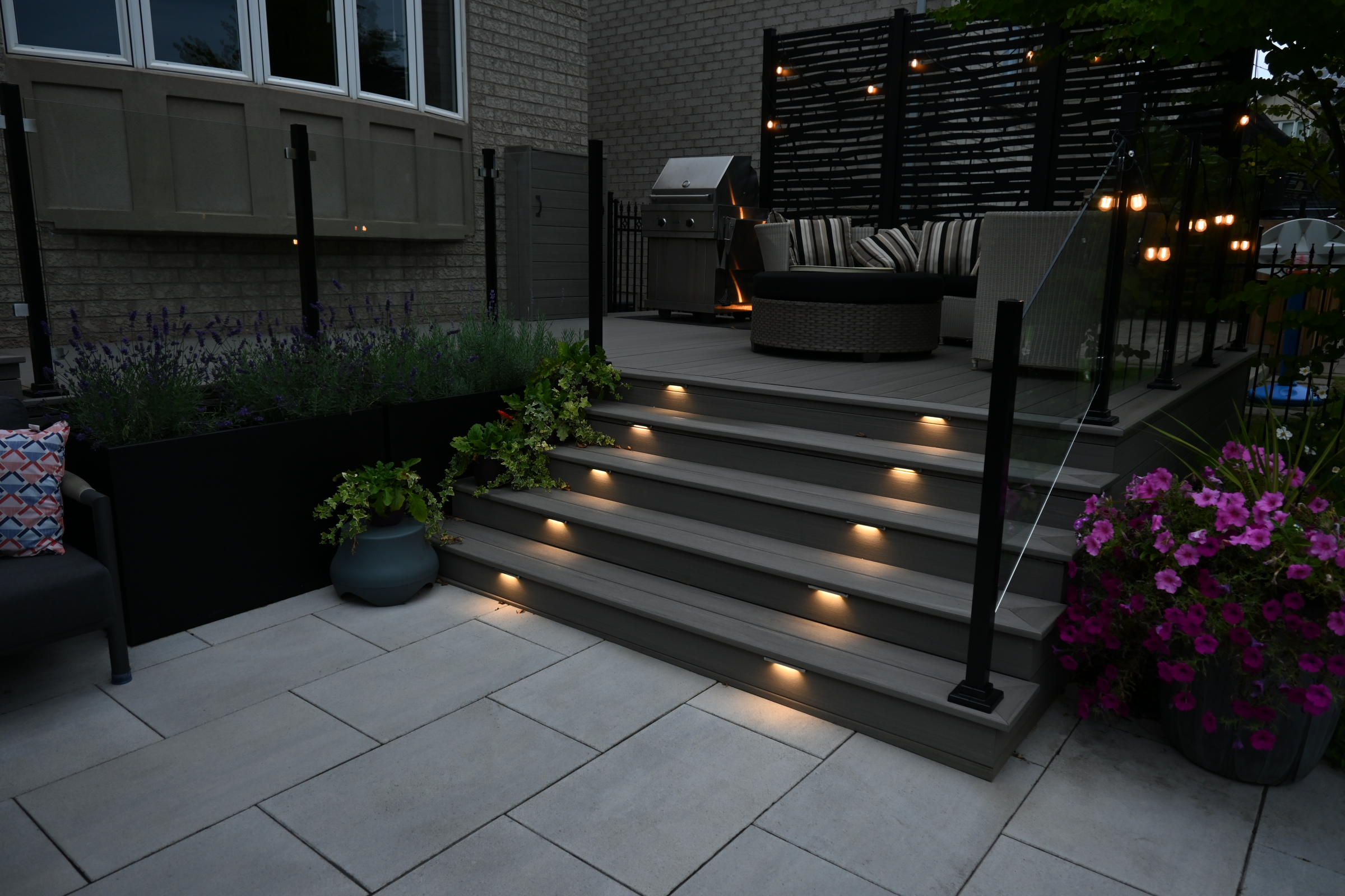 Patio with modern deck, lighting, and plants