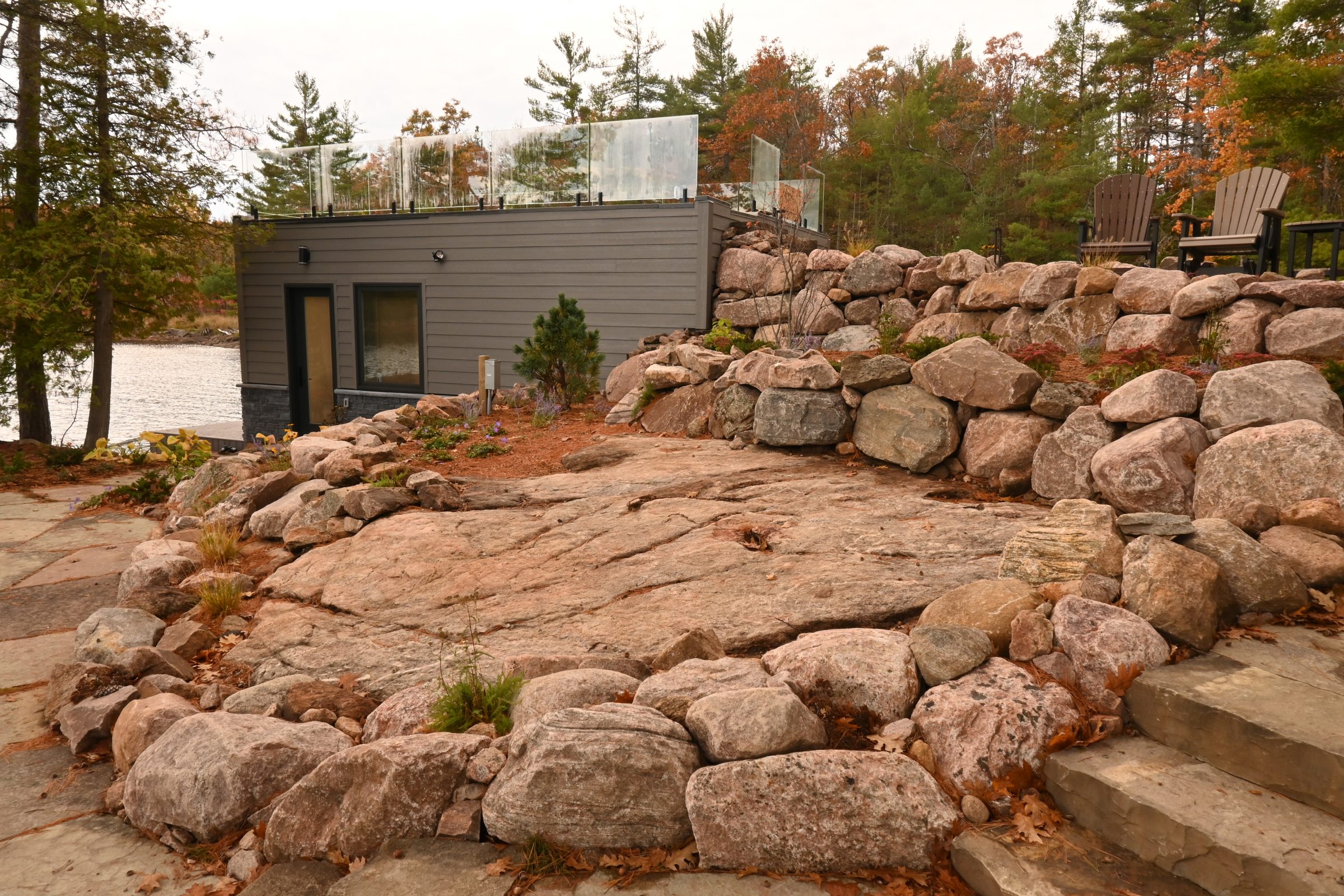 Modern cabin with stone landscaping by lake