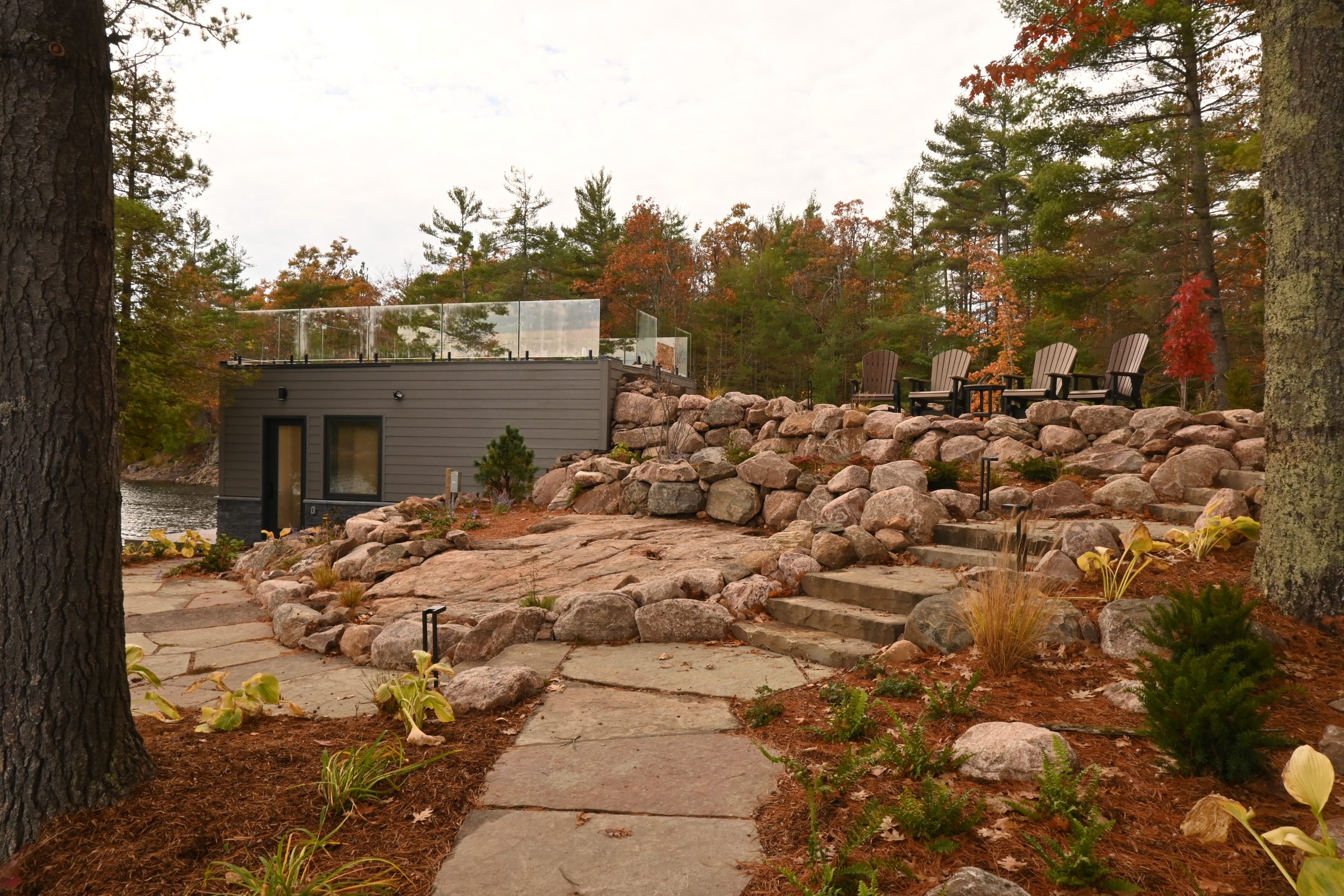 Rustic patio with stone steps in forest setting.