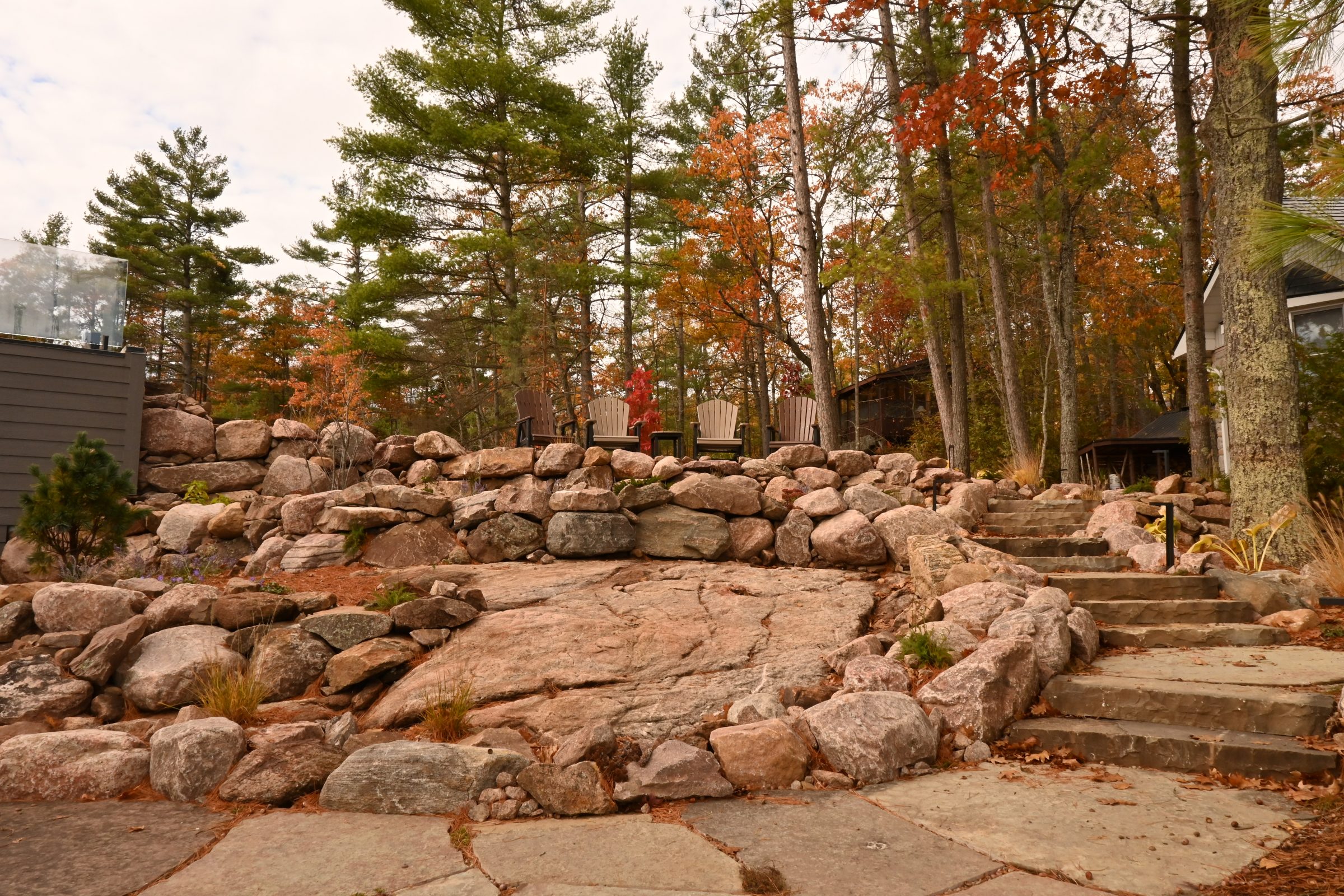 Woodland patio with stone steps and chairs.