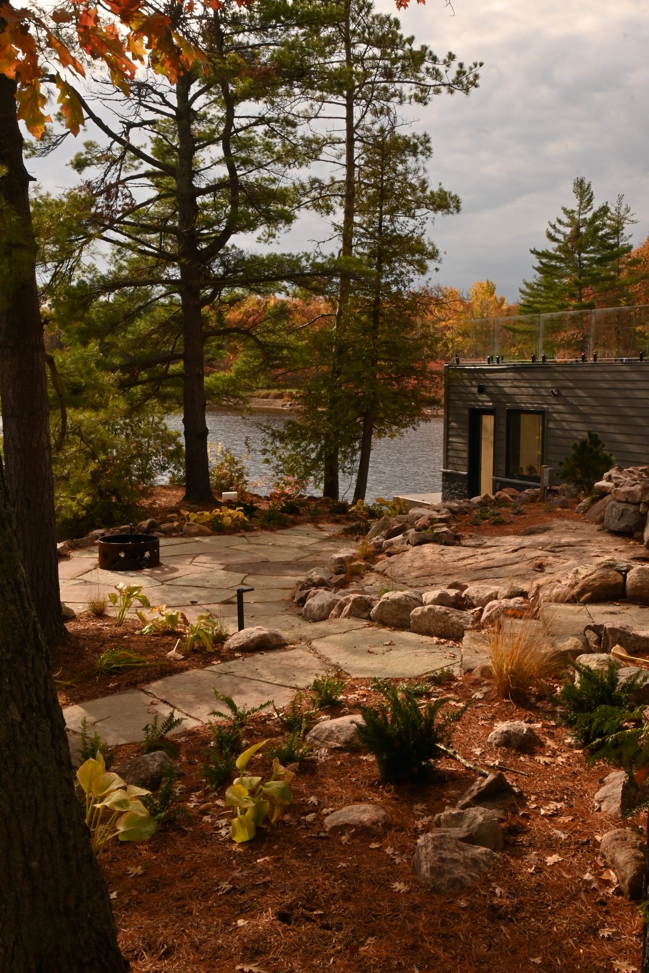 Lakeside cabin surrounded by autumn trees.