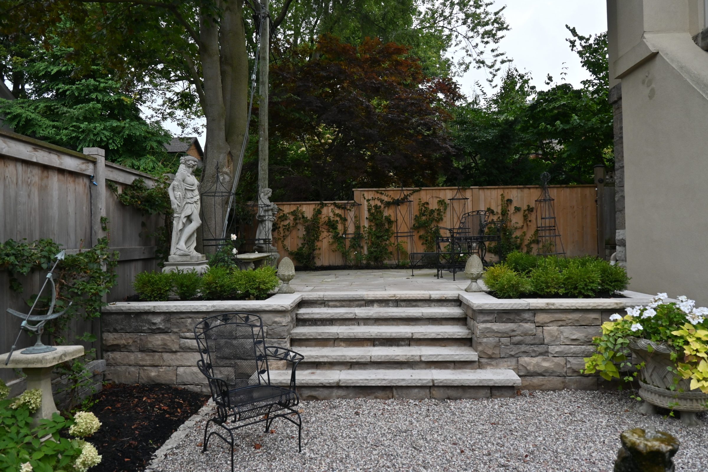 Elegant garden patio with statues and seating