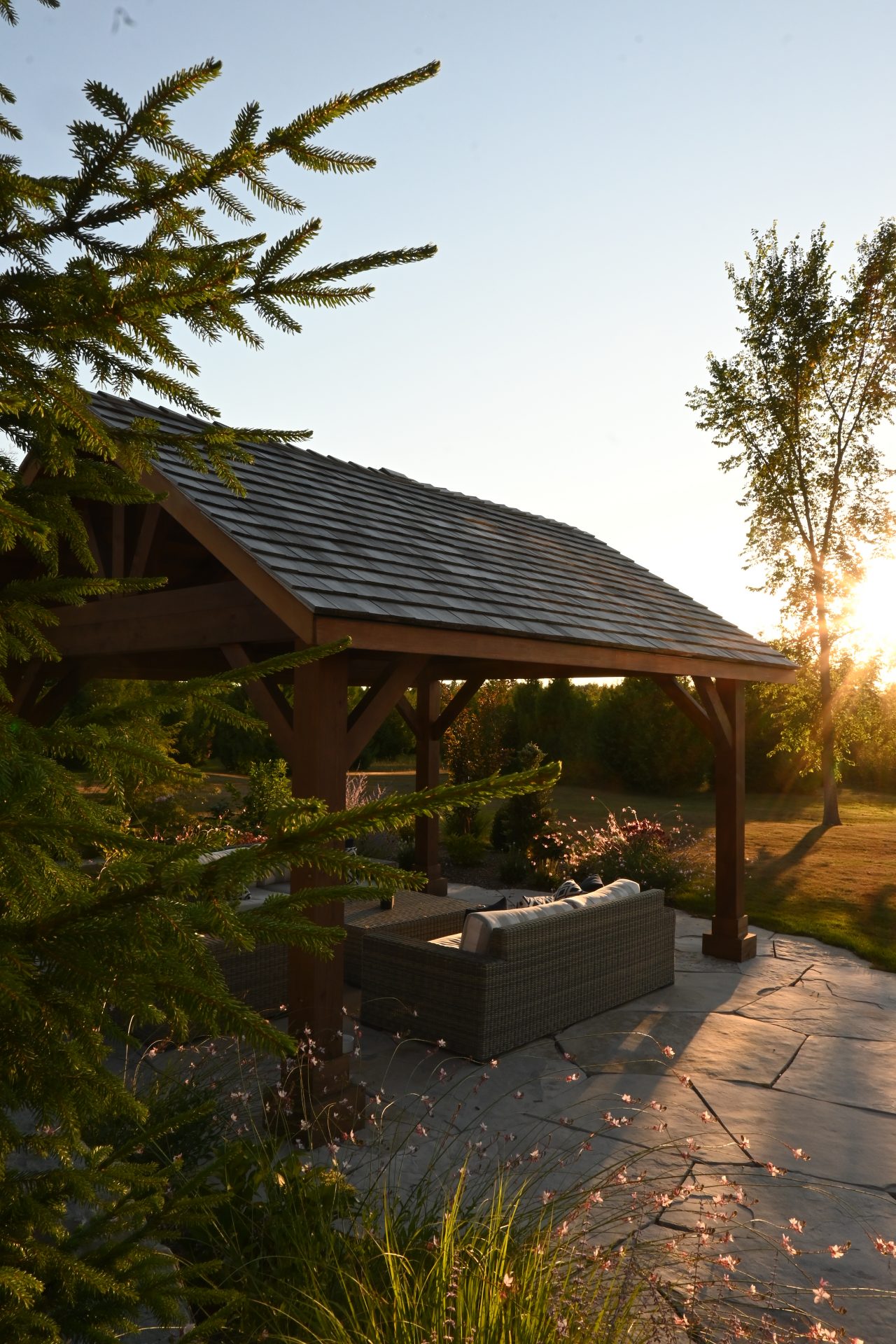 Sunset over outdoor patio with wooden gazebo.