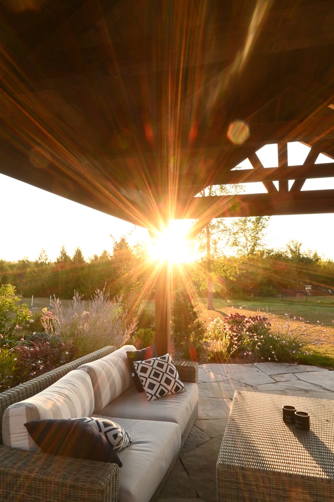 Sunset view from cozy outdoor patio seating area.