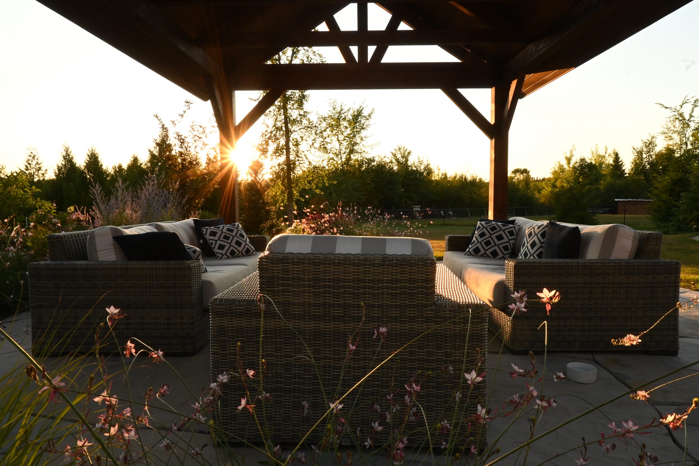 Outdoor patio with wicker furniture at sunset.