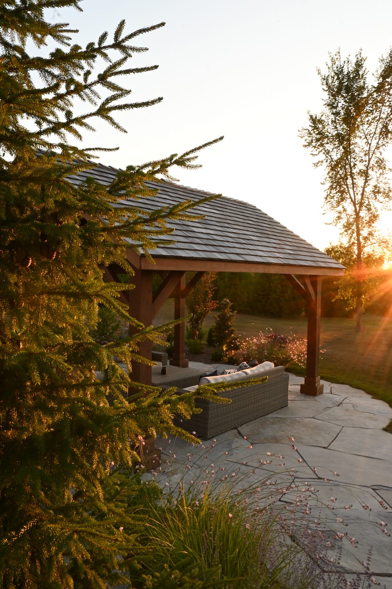 Sunset over cozy backyard patio with trees.