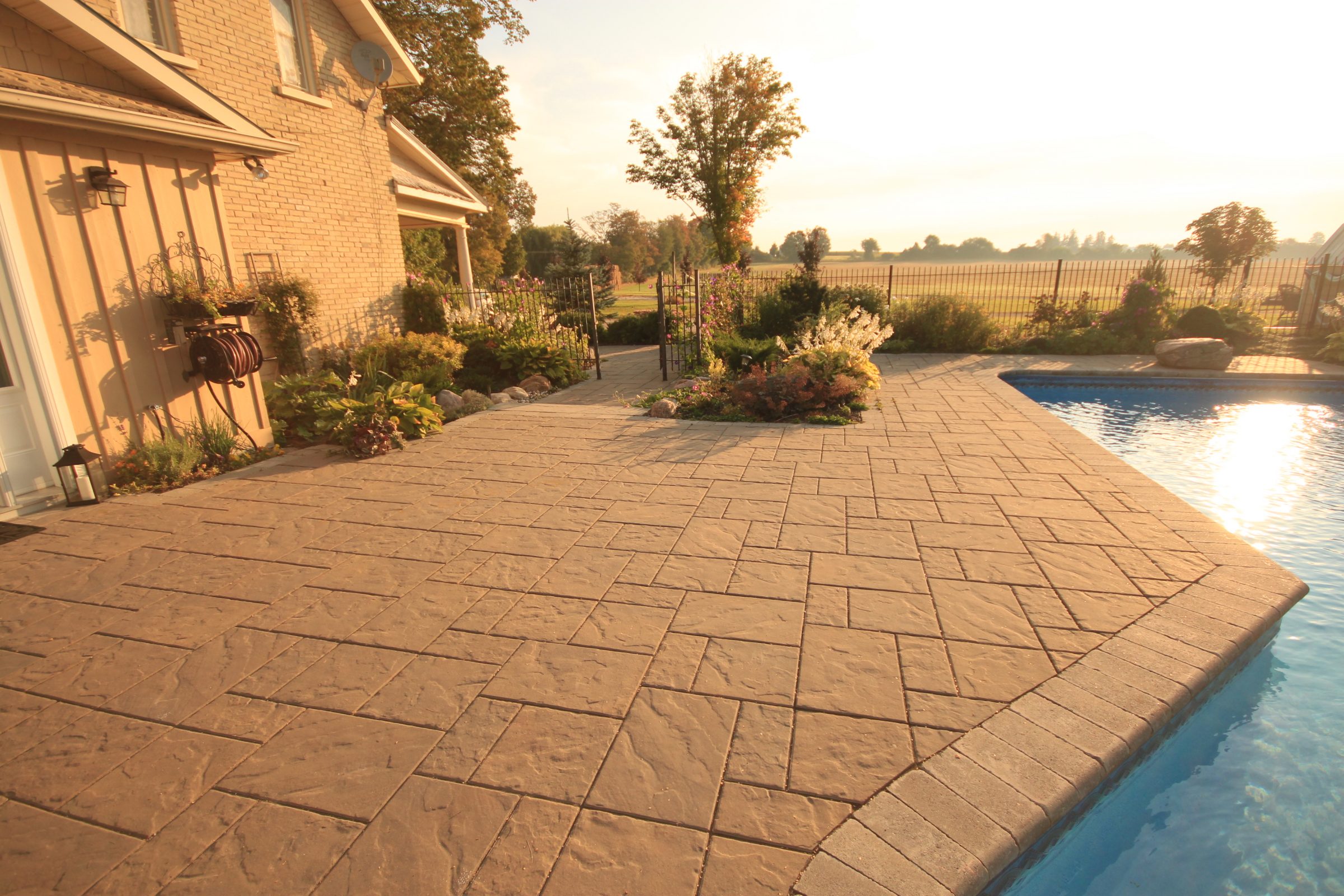 Sunny backyard patio with pool and garden