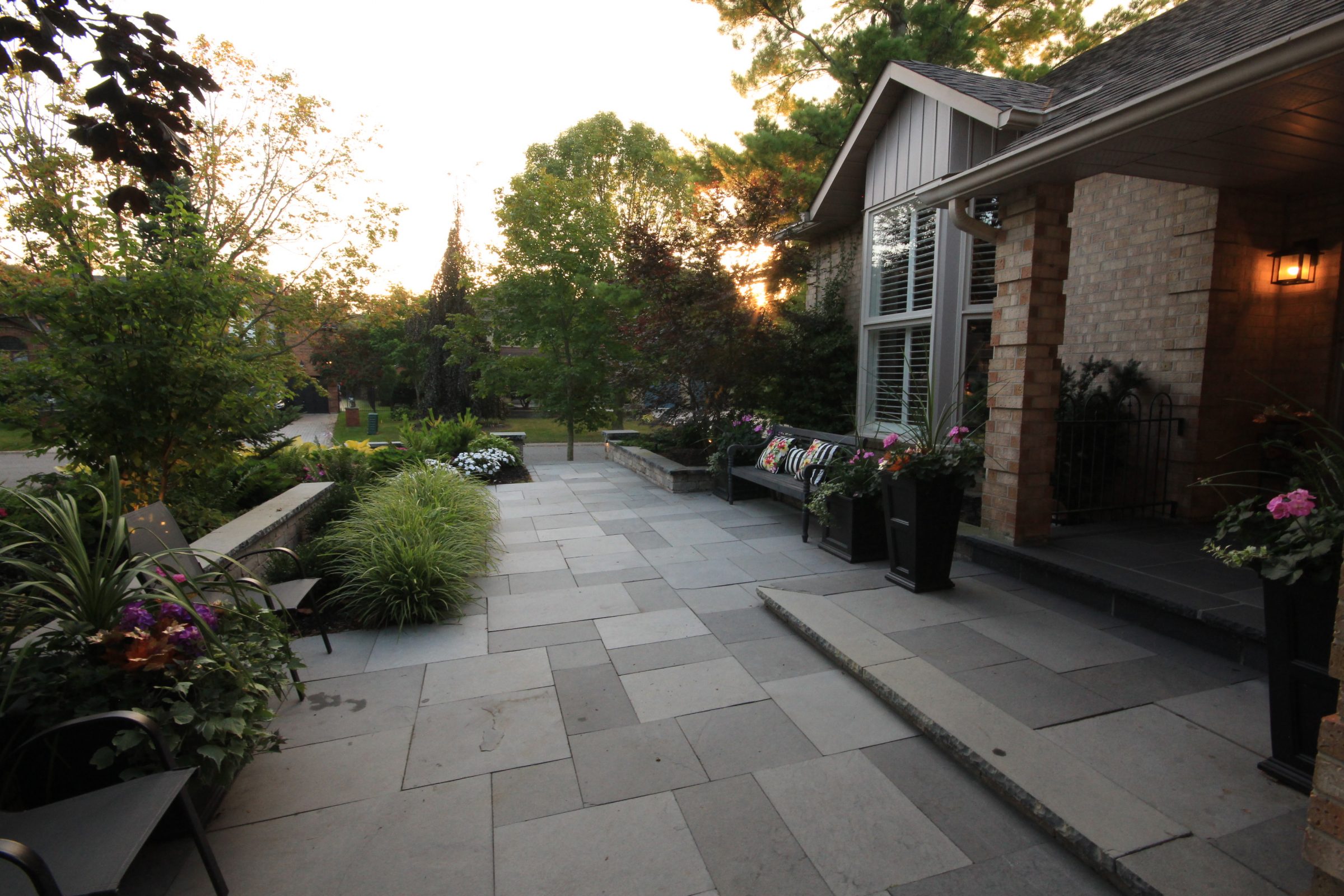 Elegant house entrance with garden at sunset.