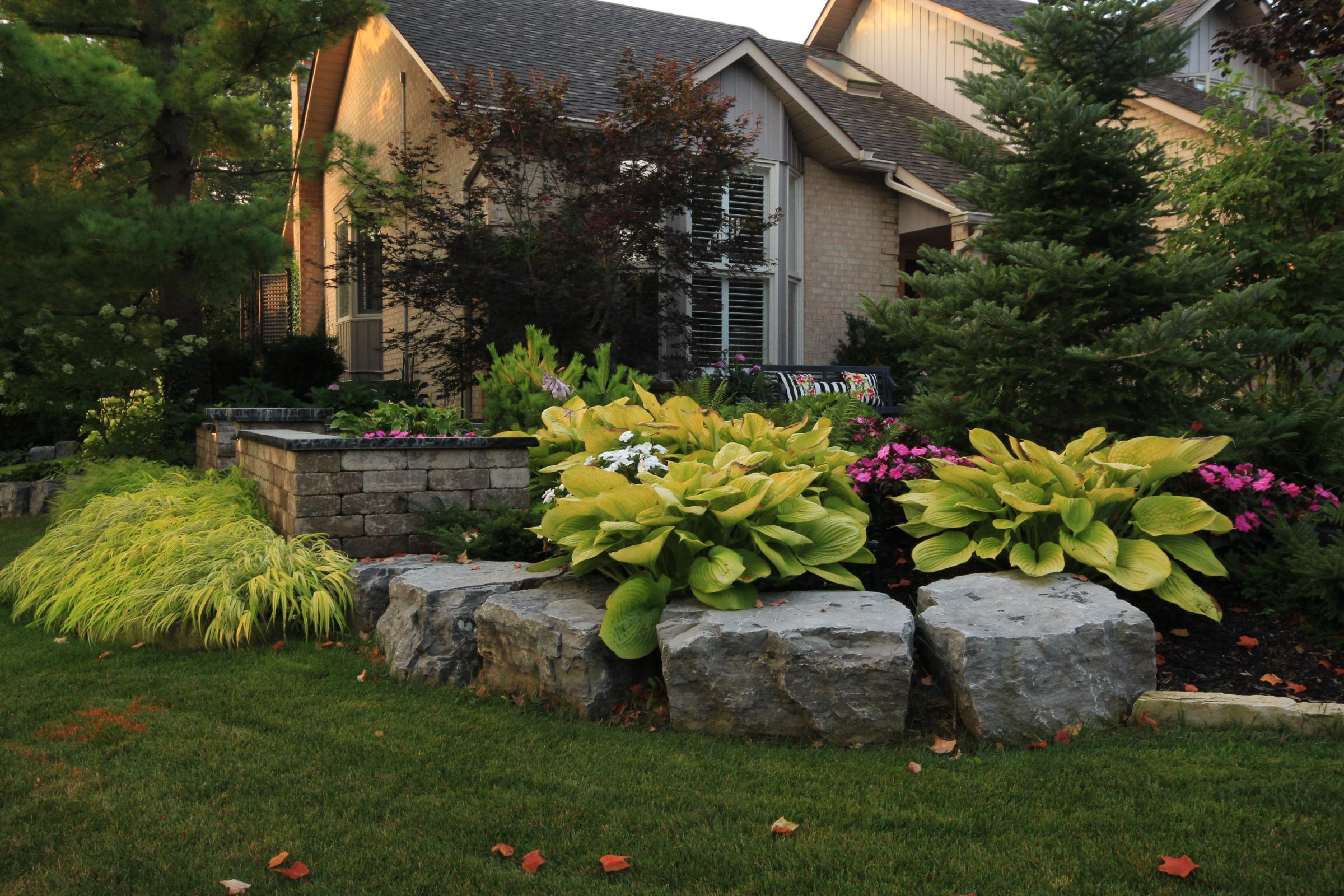 Lush garden with plants and stone landscaping.