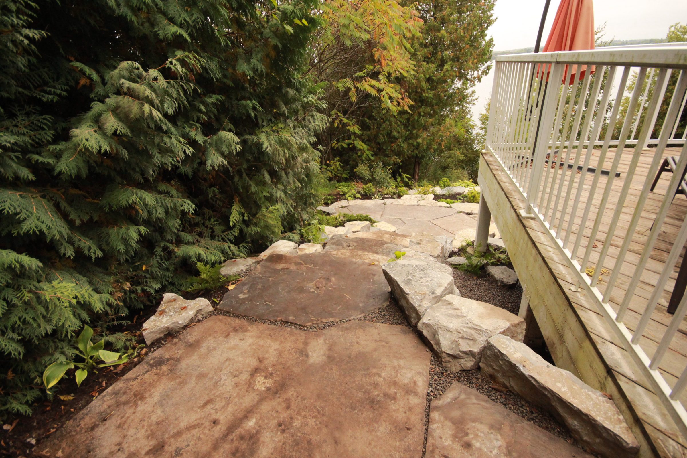 Stone pathway next to deck and greenery