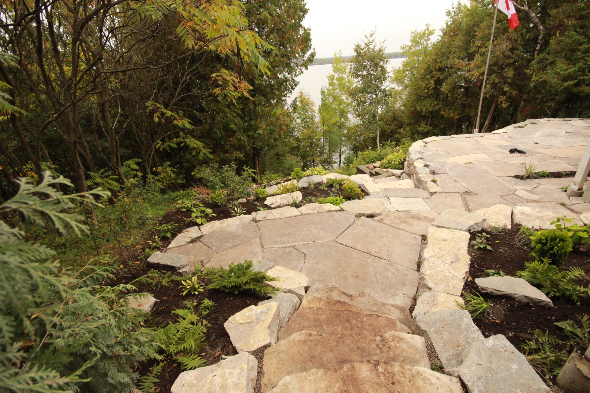 Stone pathway leading to scenic lakeside view.