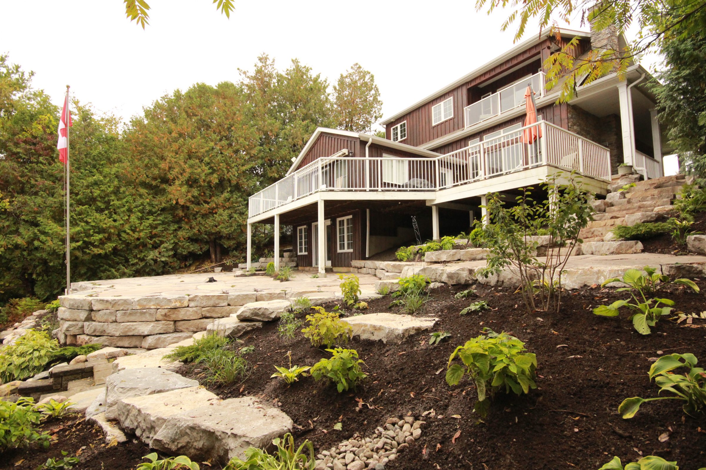 Rustic house with stone landscaping and flagpole.