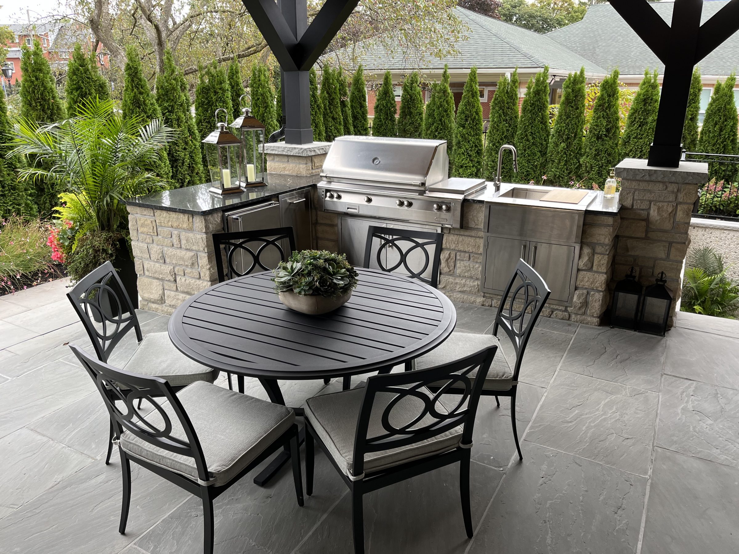Outdoor patio with grill, sink, and dining set