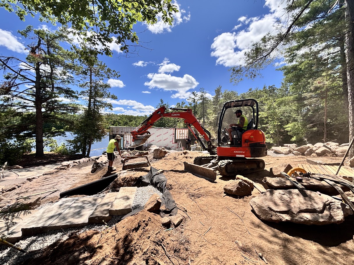 Construction site with workers and machinery in forest.