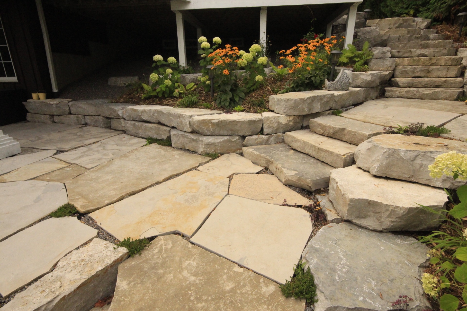 Stone patio with stairs and colorful flowers
