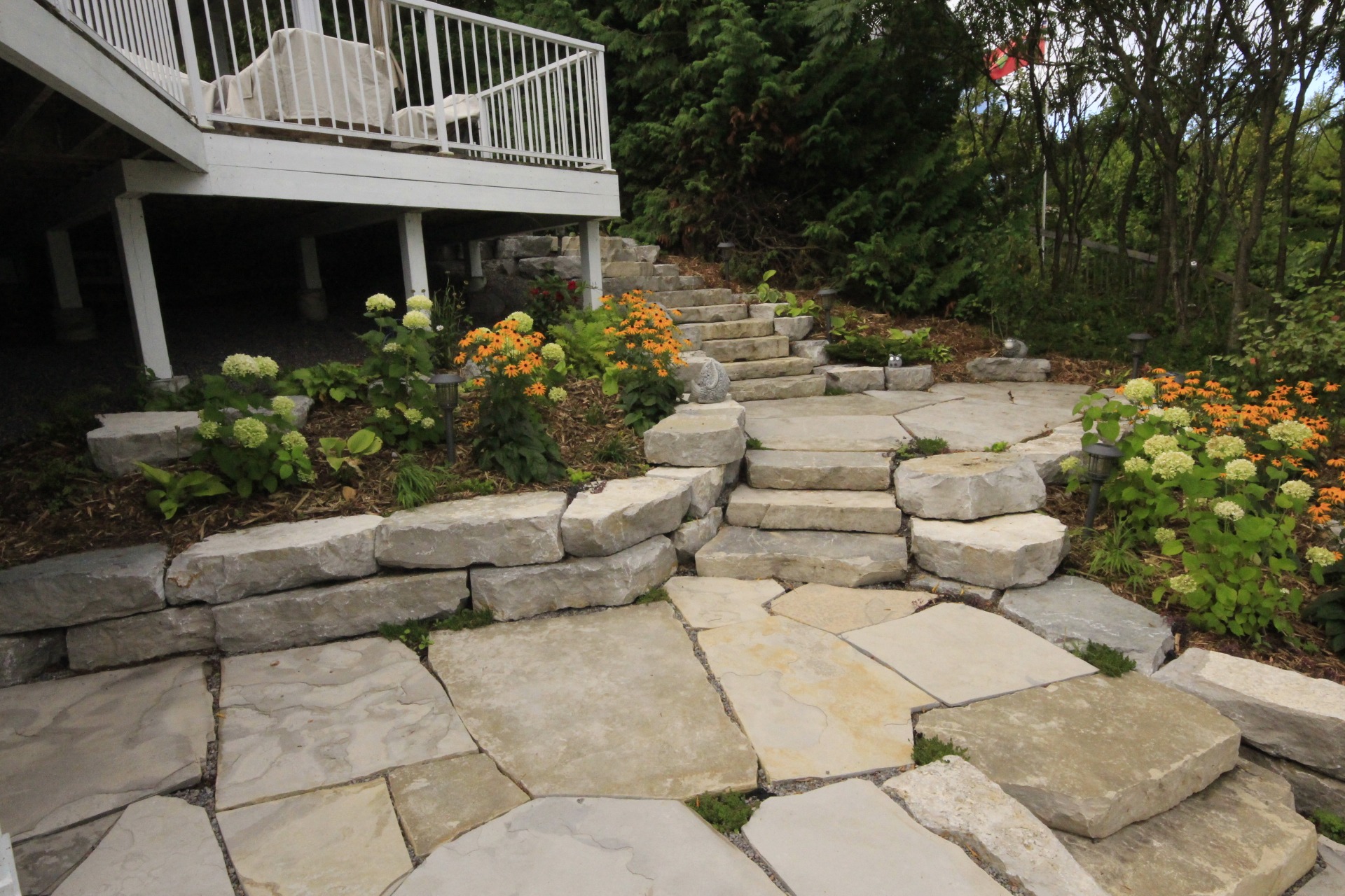 Stone patio with stairs and flowering plants