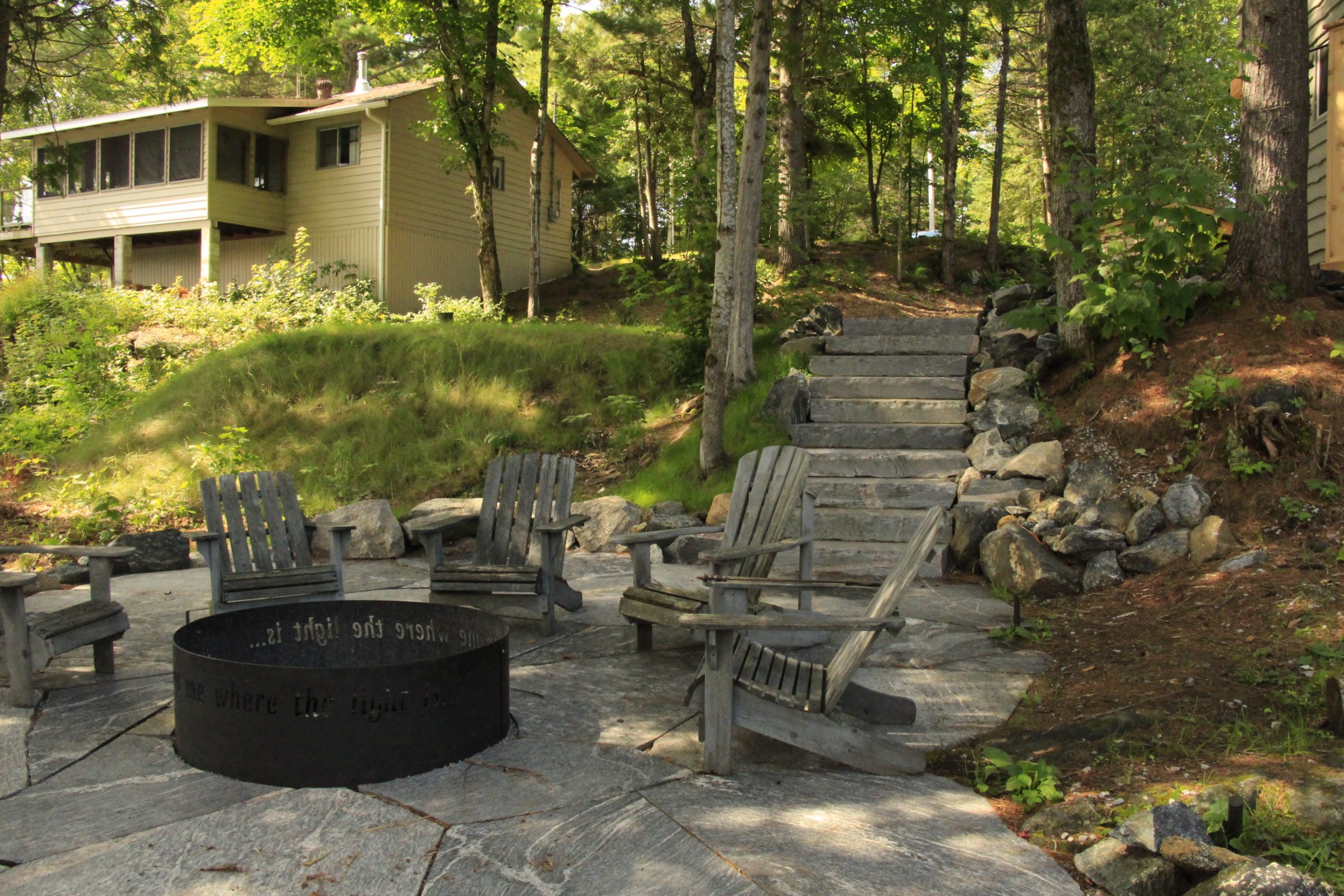 Secluded cabin with outdoor seating and stone steps.
