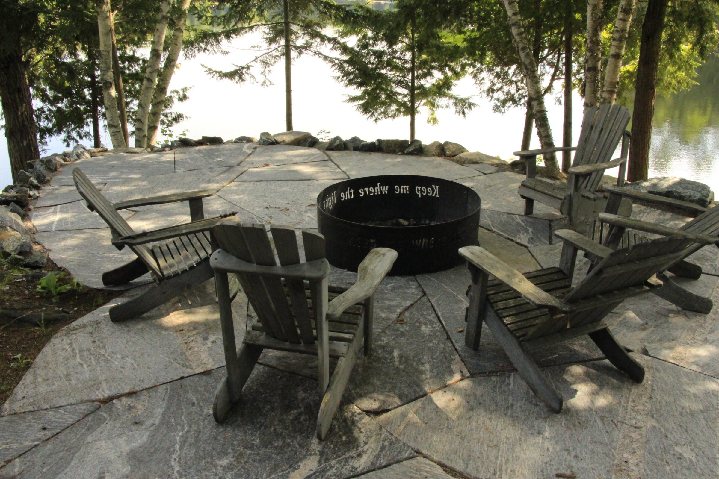 Outdoor fire pit surrounded by Adirondack chairs