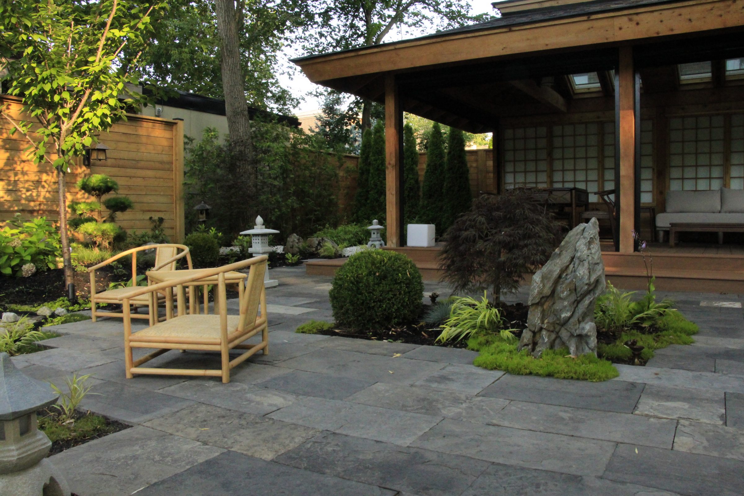 Serene Japanese garden with chairs and rock formations.