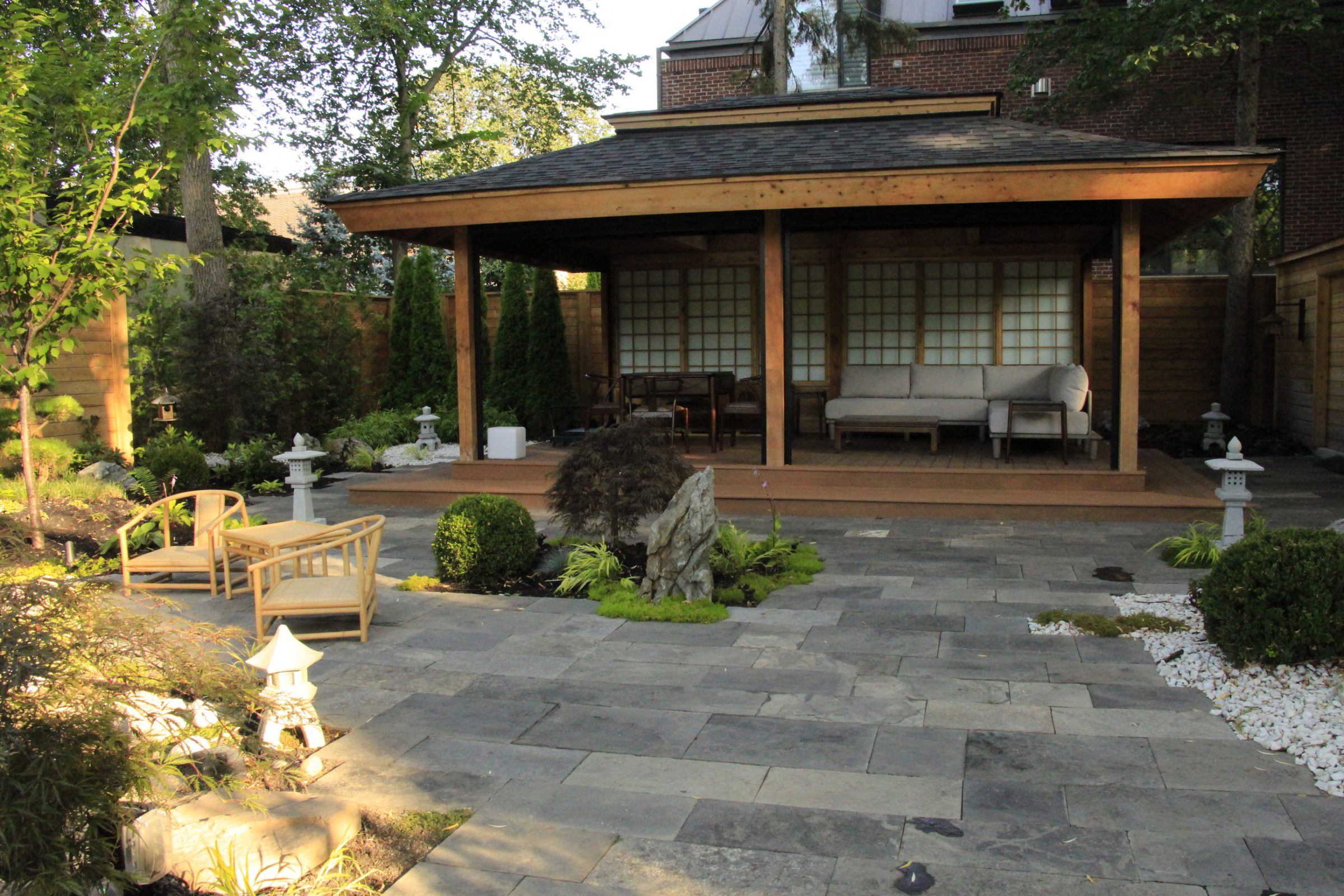 Japanese-style garden with wooden pavilion and seating area.