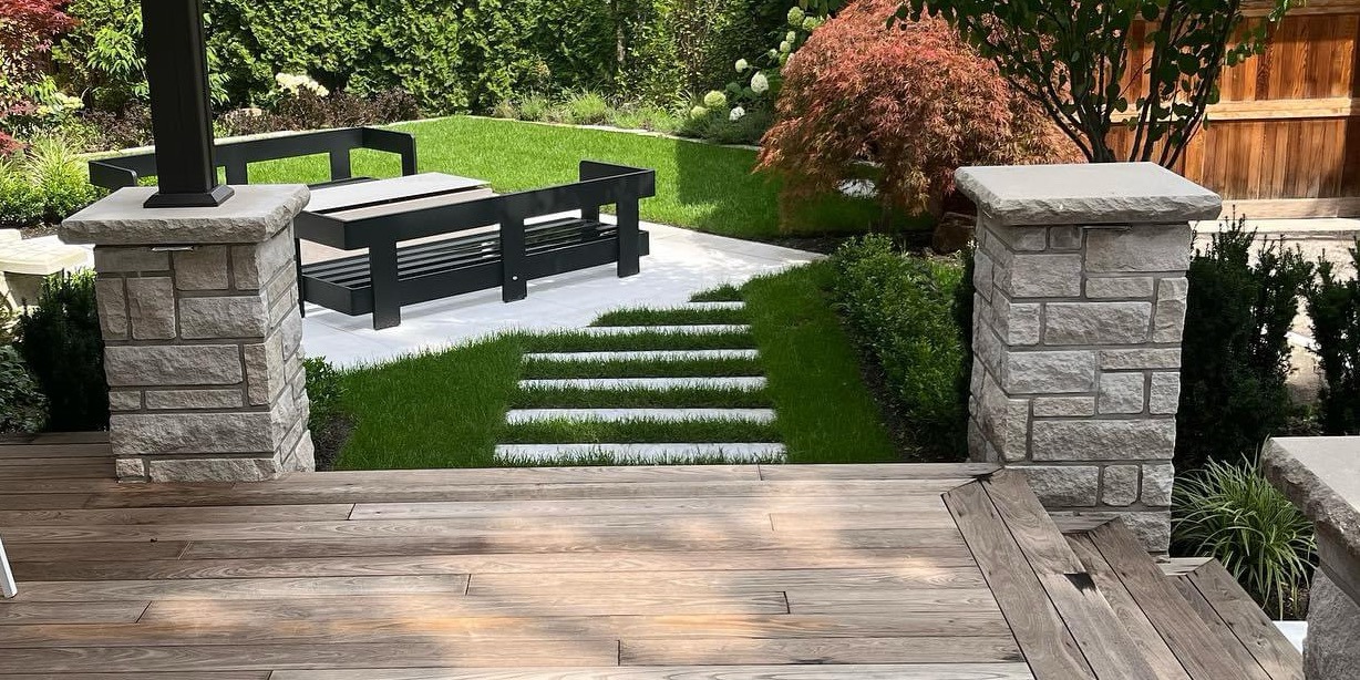 Modern garden with stone steps and patio seating.