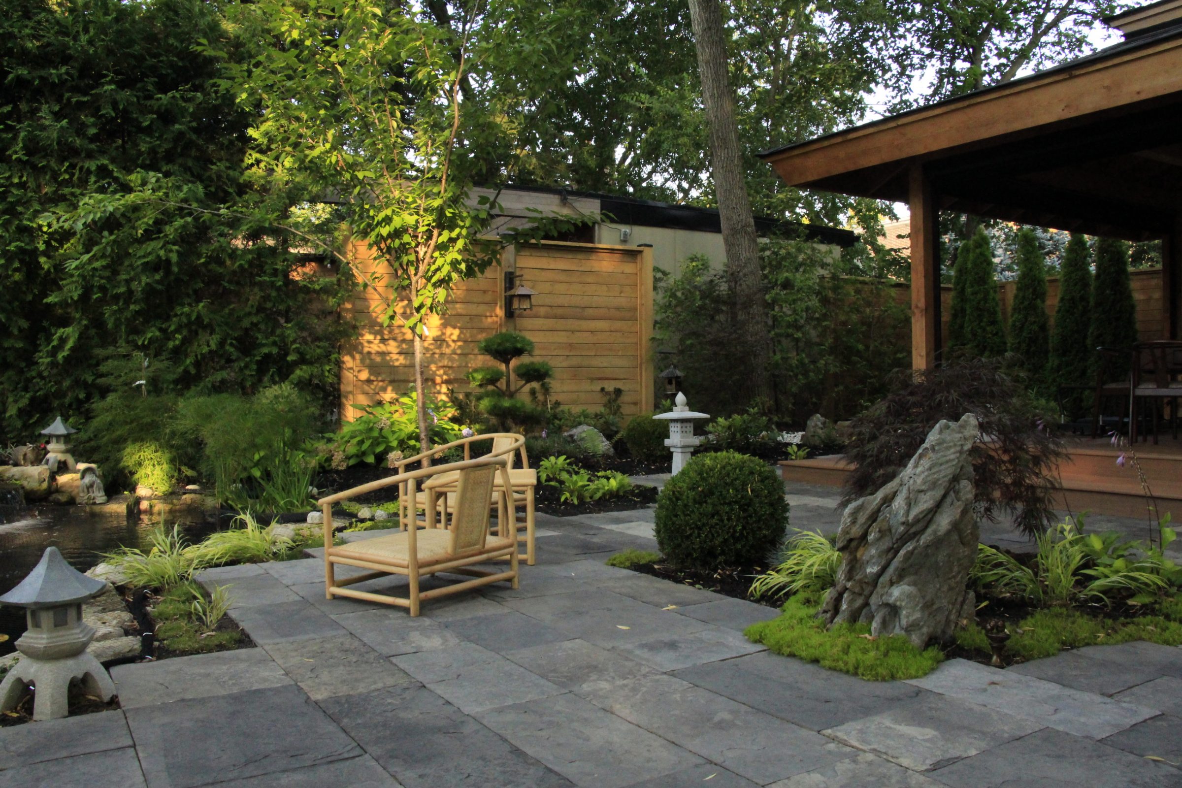 Tranquil garden patio with wooden chair and plants.